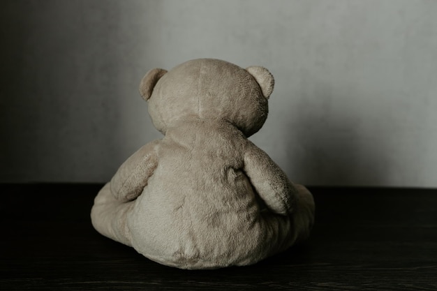 Kindesmissbrauchskonzept Teddybär, der allein in einem Raum sitzt