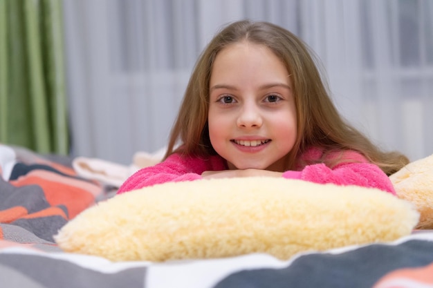 Kindheit des positiven Teenager-Mädchens im Bett entspannen Kindheit des Teenager-Mädchens im Schlafzimmer entspannen