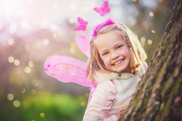 Kindheit ist magisch Porträt eines entzückenden kleinen Mädchens, das als Fee verkleidet ist und draußen Spaß hat