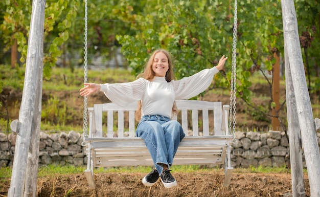 Kindheitsglück. Entspannen Sie sich im Park. sommerliche Aktivität. positive Gefühle. Fühle die Freiheit. frohes Kind auf Schaukel. Kind schwingt im Freien. Teenager-Mädchen, das sich auf dem Spielplatz amüsiert.