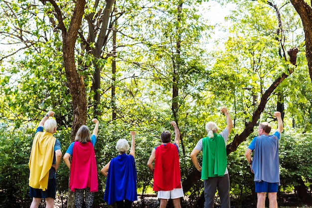 Kindliche Senioren, die Superheldkostüme tragen