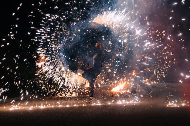 KINESHMA RUSSLAND 09. OKTOBER 2021 Mädchen mit brennender funkelnder Fackel präsentiert eine Feuershow und pyrotechnische Performance