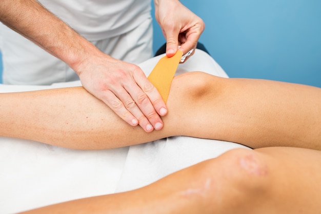 Kinesio gravando aplicação de joelho de fisioterapeuta