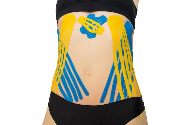 Kinesio tape en el abdomen de una mujer joven