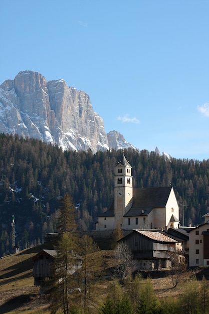 Kirche auf dem Hügel mit verschneiten Bergen, Italien