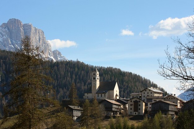 Kirche auf dem Hügel mit verschneiten Bergen, Italien