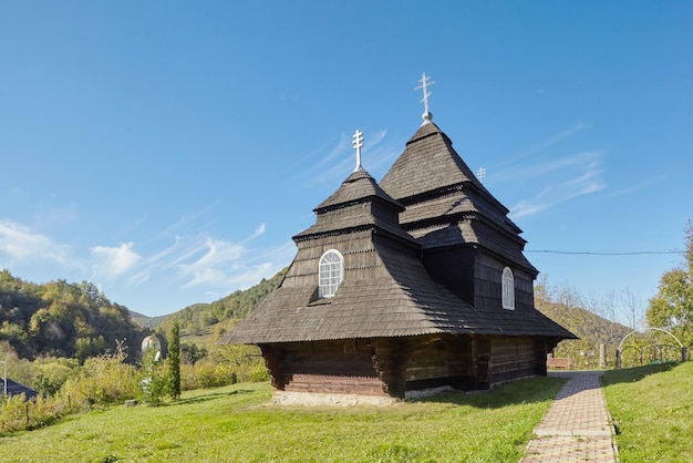 Kirche des Erzengels Michael Altes Holzgebäude in den Bergen wunderbares sonniges Herbstwetter Bäume im Herbstlaub wolkenloser Himmel Uzhok Ukraine