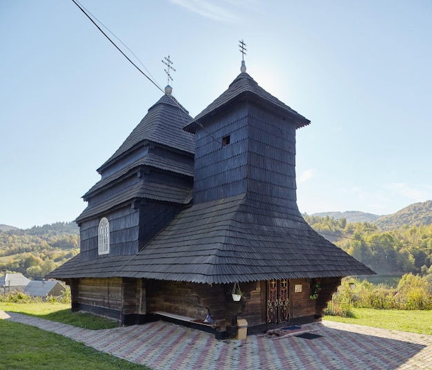 Kirche des Erzengels Michael Altes Holzgebäude in den Bergen wunderbares sonniges Herbstwetter Bäume im Herbstlaub wolkenloser Himmel Uzhok Ukraine