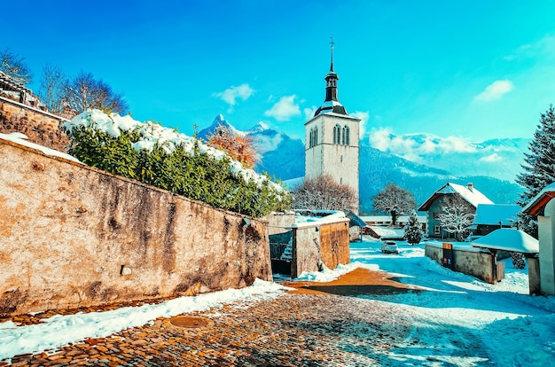 Kirche und Alpenberge des Gruyeres-Stadtdorfes in der Schweiz im Winter