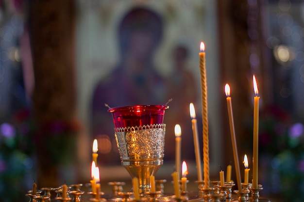 Kirchenkerzen auf dem Hintergrund von Ikonen Religion