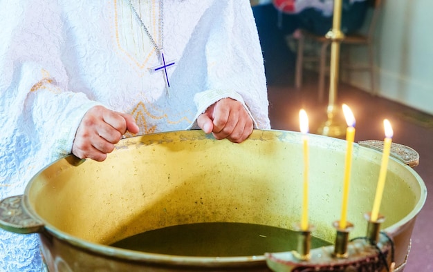 Foto kirchliche taufe bei der taufe der orthodoxen christen wird das kreuz ins wasser gelassen