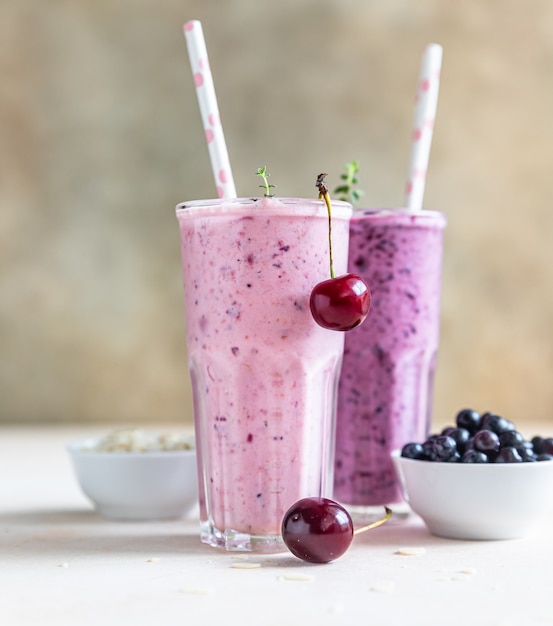 Kirsch- und Blaubeer-Smoothie im Glas mit Strohhalm. Gesundes Frühstück.