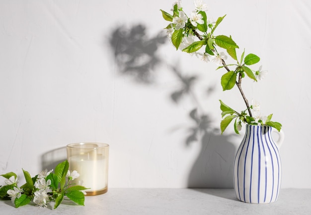 Kirschbaumblüten in gestreifter Vase und Duftkerze Blumenstillleben-Szenenmodell