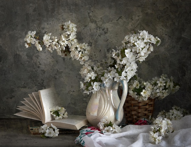 Kirschblüten in weißer Vase auf grauem Hintergrund. Frühlingsstillleben.