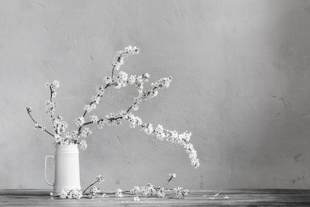 Foto kirschblumen im weißen krug auf altem holztisch