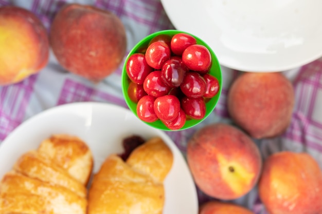 Kirschen sind saftig, hell, süß auf einer Picknick-Tischdecke