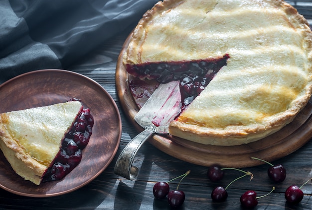 Kirschkuchen auf dem hölzernen Hintergrund