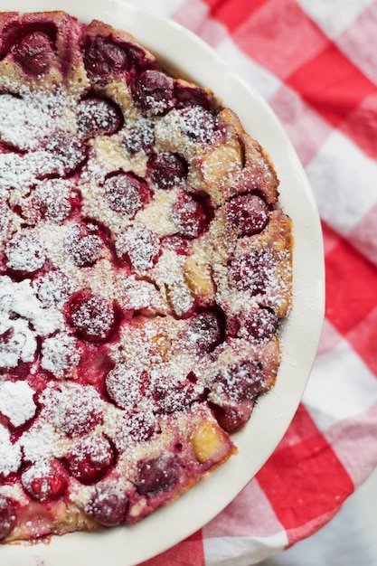 Foto kirschkuchen mit sahnefüllung französisches dessert clafoutis mit roten süßkirschen puderzucker backform mit leckerer torte