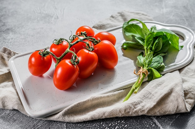 Kirschtomaten auf einem weißen Hintergrund mit Basilikum. Draufsicht.