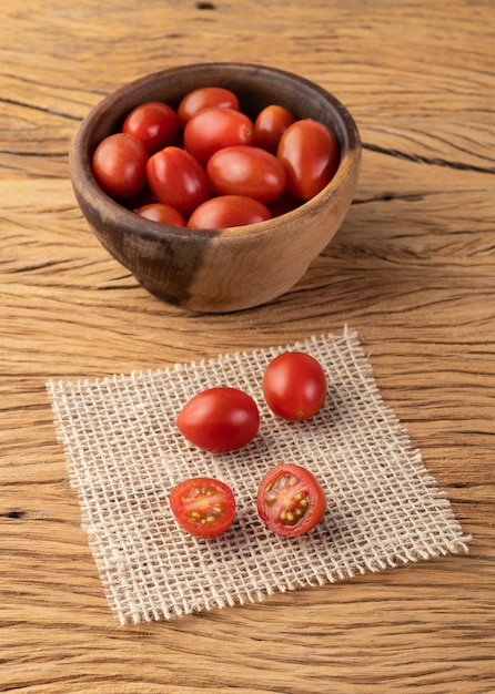 Kirschtomaten auf einer Schüssel über Holztisch.