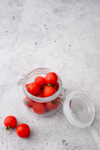 Kirschtomaten in einem Glas auf grauem Hintergrund