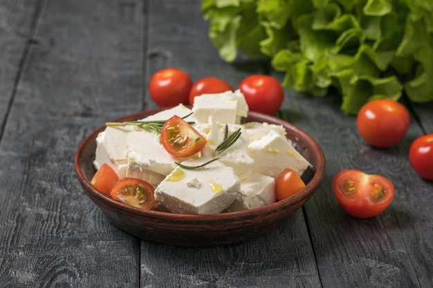 Kirschtomaten mit Feta-Käsescheiben auf dem Tisch. Salat mit Käse und Gemüse.