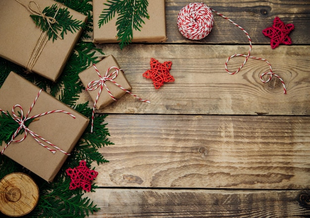 Kisten in Kraftpapier verpackt, Zweige auf Holzhintergrund. Umweltfreundliches Material.Weihnachten und Neujahr.