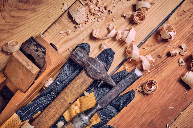 Kit de ferramentas de carpinteiro martelo cinzel e avião com fundo de madeira de luvas