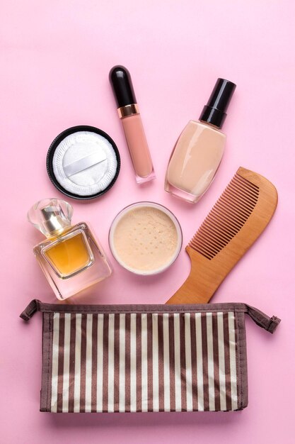 Kit de maquiagem Cosméticos femininos em uma bolsa de cosméticos e pincéis de maquiagem em um fundo rosa brilhante mulher vista superior