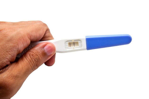 Kit de prueba de embarazo de mano recortada contra un fondo blanco