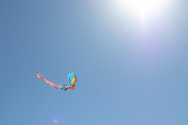 Kite contra um céu azul com a luz do sol Sun flare e copie o espaço