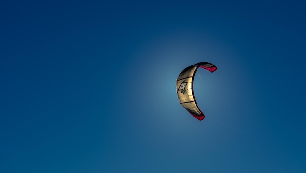 Los kitesurfistas navegan en el cielo azul