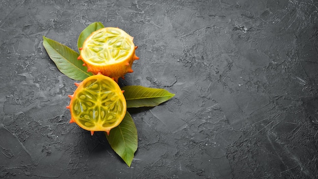 Kiwano em um fundo preto. Frutas tropicais. Vista do topo. Espaço livre para texto.