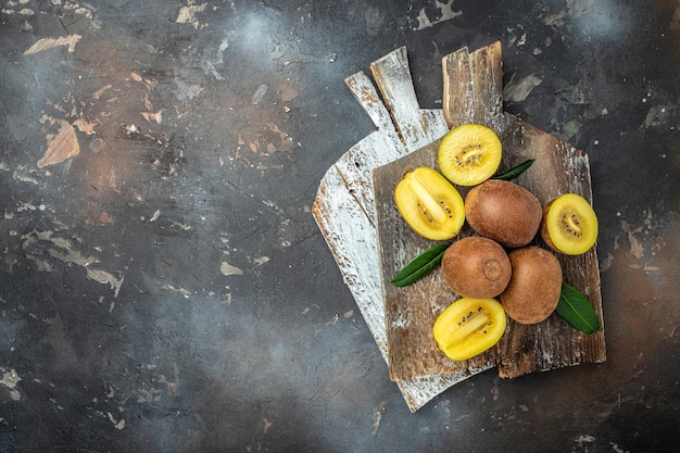 Foto kiwi dorado en un lugar de recetas de menú de banner de tabla de madera para la vista superior de texto