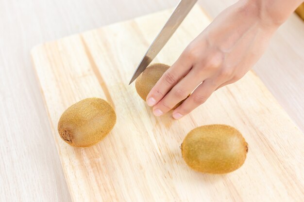 Kiwi e fatias na tábua de madeira