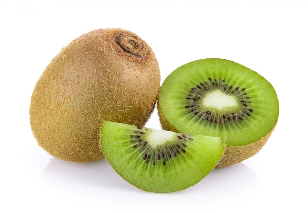 Kiwi entero y sus segmentos en rodajas sobre fondo blanco.