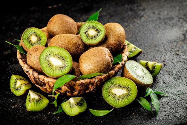 Kiwi fresco con hojas en una canasta