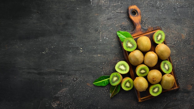 Kiwi fresco y hojas verdes sobre la mesa Estilo rústico Frutas Vista superior Espacio libre para texto