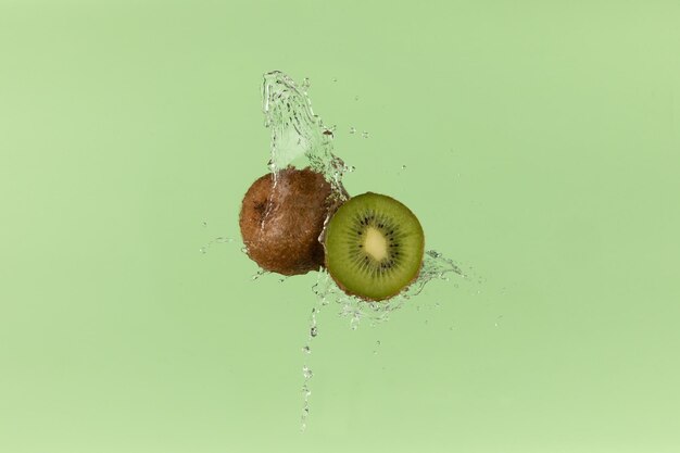 Kiwi fresco sobre fondo verde con un toque de agua