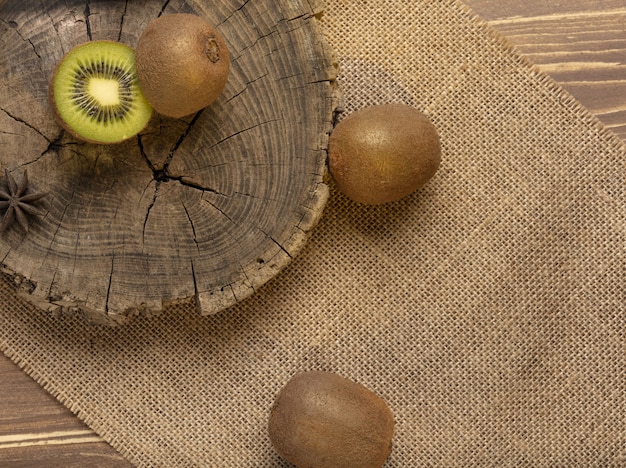 Kiwi y Kiwi en rodajas en la madera