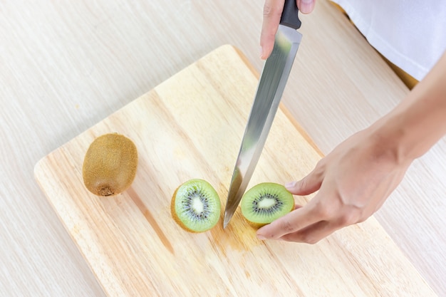 Kiwi y rodajas sobre tabla para cortar madera