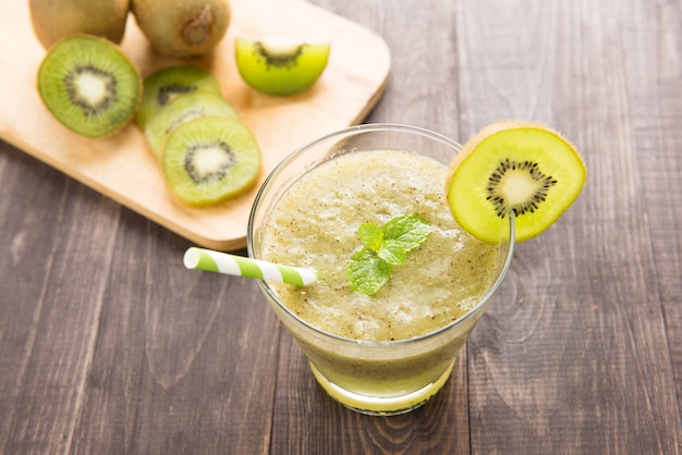 Kiwi Smoothie mit frischen Früchten auf Holztisch