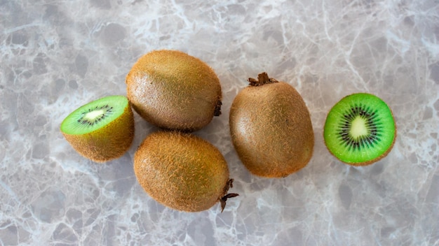 Kiwis auf Marmortisch. Kiwi von oben. Konzept der gesunden Ernährung.