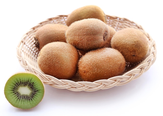 Kiwis en una canasta sobre fondo blanco.