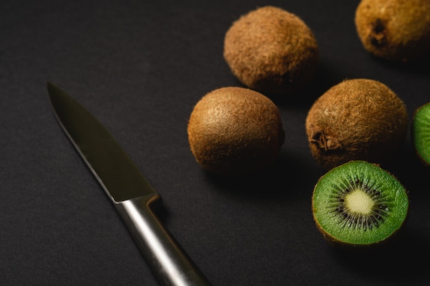 Kiwis cortados metade com faca de cozinha, vista de ângulo