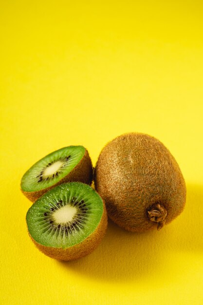 Kiwis halb geschnitten auf leuchtendem Gelb