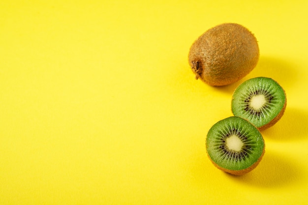 Kiwis halb geschnitten auf leuchtendem Gelb