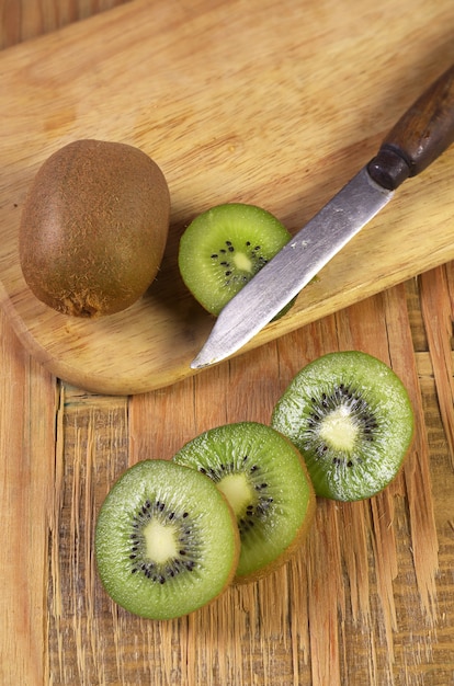 Kiwis maduros y cortar en mesa de madera antigua