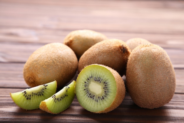 Kiwis maduros e meio kiwis no fundo marrom