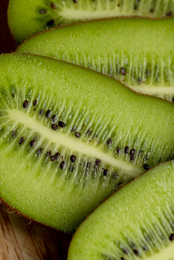 Kiwis maduros verdes fatiados estão sobre a mesa cozinhando um prato com kiwis maduros
